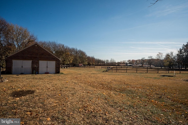 view of yard with an outbuilding and a rural view