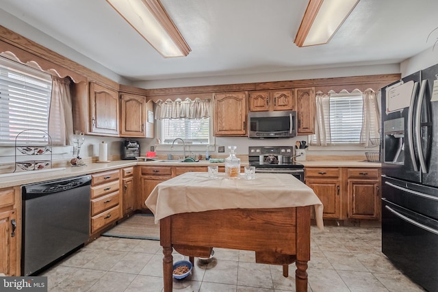 kitchen with sink, light tile patterned floors, and stainless steel appliances