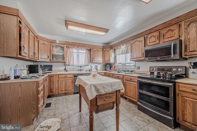 kitchen featuring sink, light tile patterned flooring, and appliances with stainless steel finishes