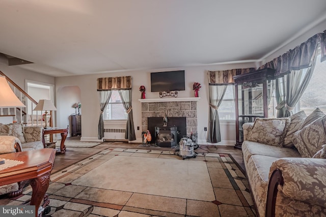 living room featuring a wood stove and wood-type flooring