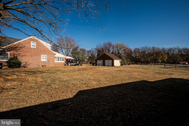 view of yard featuring a garage and an outdoor structure