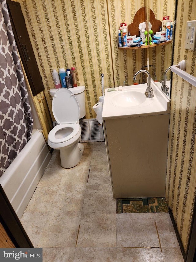 full bathroom featuring shower / bath combo with shower curtain, vanity, and toilet