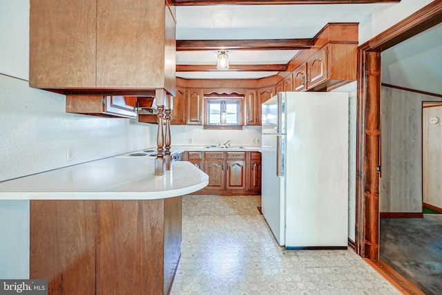 kitchen featuring sink, beamed ceiling, white fridge, cooktop, and kitchen peninsula