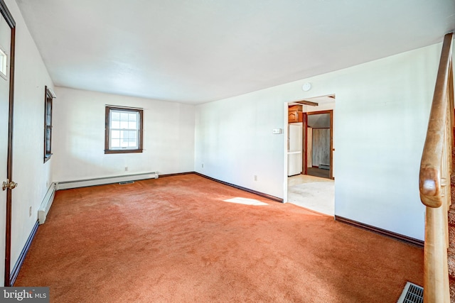 carpeted empty room with a baseboard heating unit