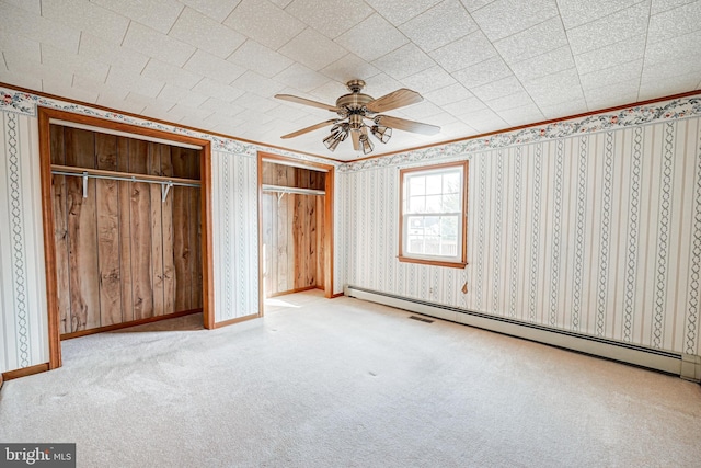 unfurnished bedroom featuring light colored carpet, baseboard heating, and ceiling fan