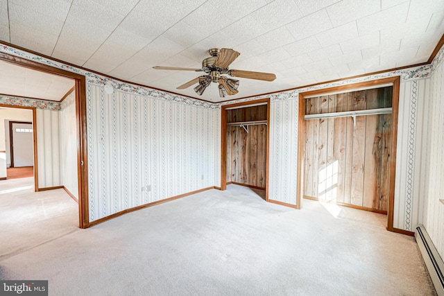 unfurnished bedroom featuring ceiling fan, multiple closets, light carpet, and a baseboard radiator