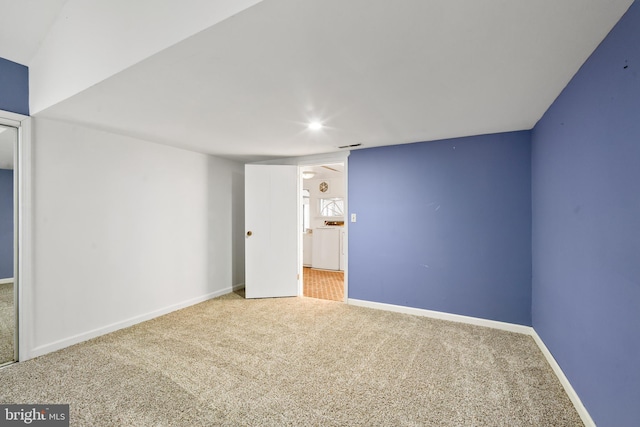 spare room featuring carpet flooring and baseboards