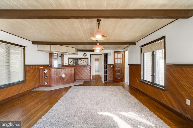 interior space featuring wooden ceiling, a wainscoted wall, wooden walls, and beamed ceiling