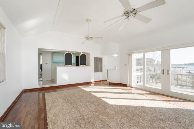 unfurnished living room with baseboards, a ceiling fan, lofted ceiling, hardwood / wood-style floors, and french doors