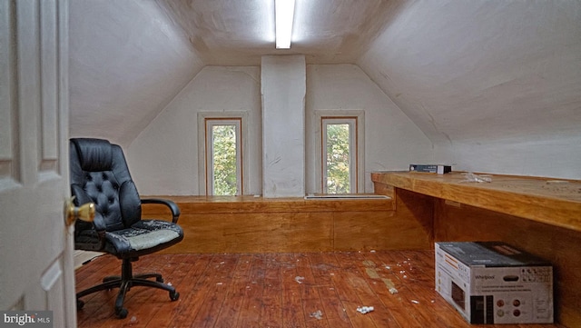 unfurnished office featuring hardwood / wood-style flooring and lofted ceiling