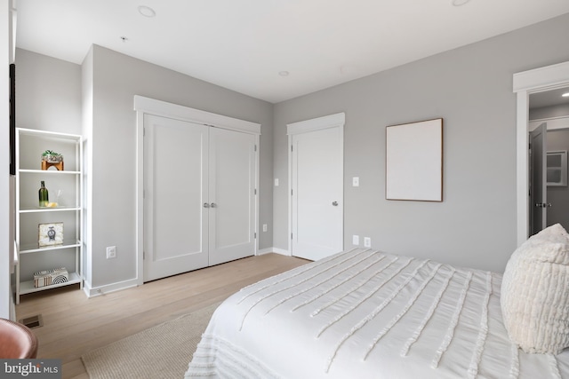 bedroom with a closet and light hardwood / wood-style flooring