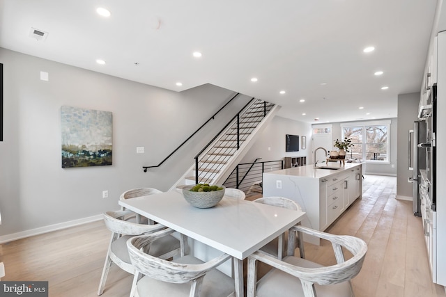 dining room with light hardwood / wood-style flooring and sink