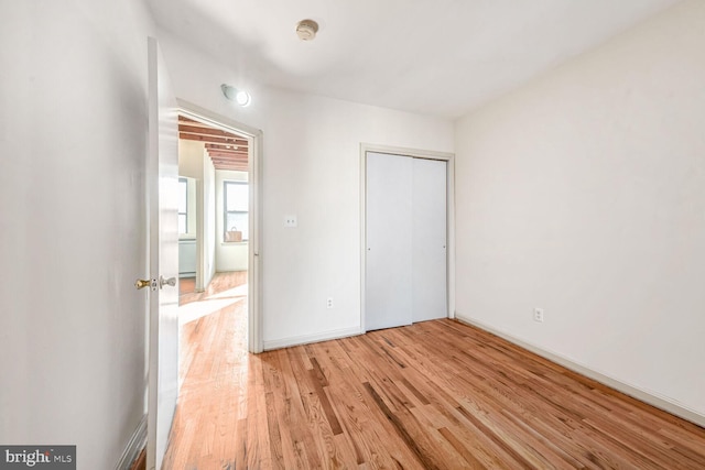 unfurnished bedroom featuring a closet and light wood-type flooring