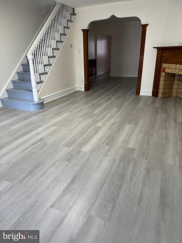 unfurnished living room featuring light hardwood / wood-style flooring and ornate columns