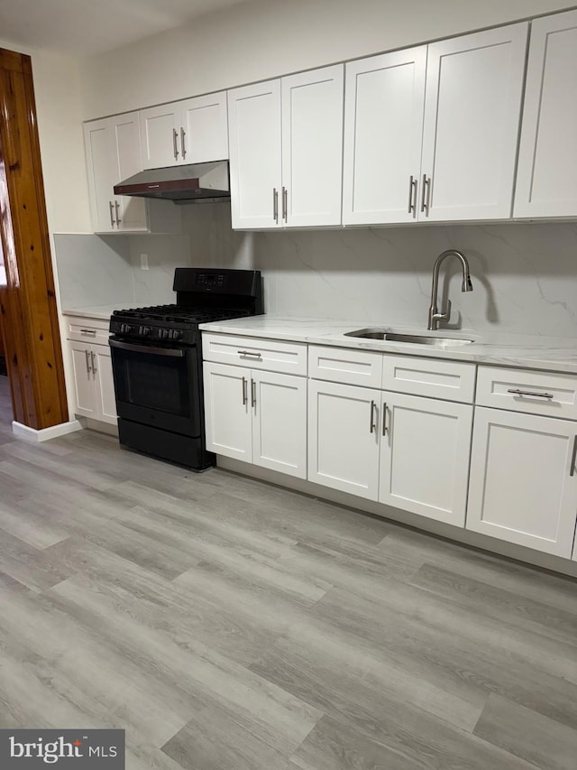 kitchen with black range with gas stovetop, sink, white cabinets, and light hardwood / wood-style flooring