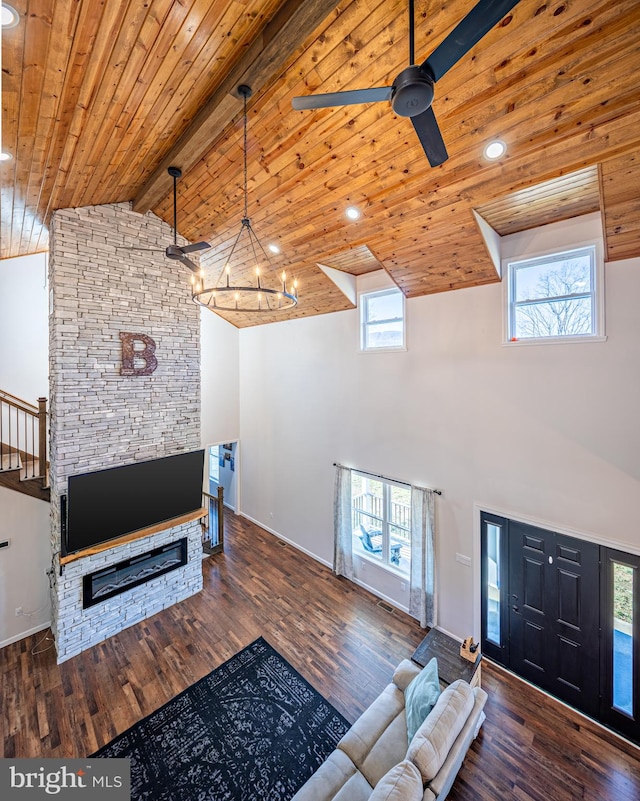 living room featuring ceiling fan with notable chandelier, dark wood-type flooring, beam ceiling, high vaulted ceiling, and wooden ceiling