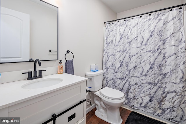 bathroom with hardwood / wood-style floors, vanity, and toilet