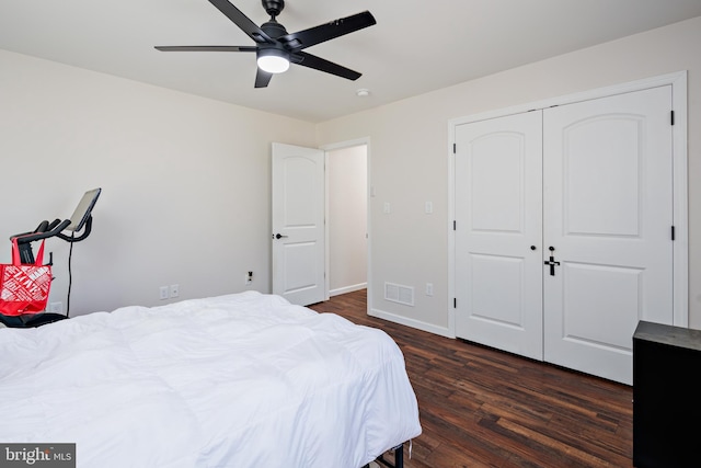 bedroom with ceiling fan, dark wood-type flooring, and a closet