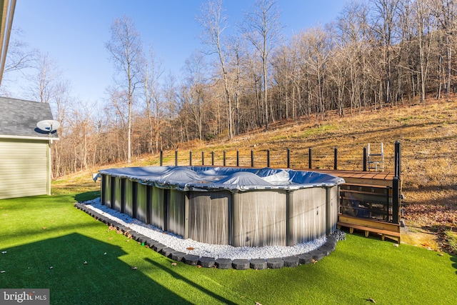 view of swimming pool featuring a yard and a wooden deck