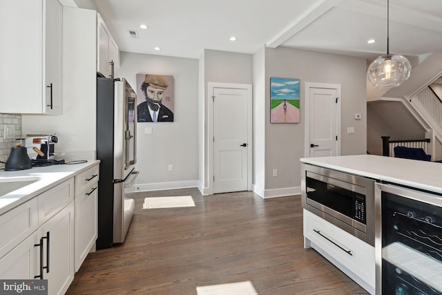 kitchen featuring appliances with stainless steel finishes, dark wood-type flooring, white cabinets, wine cooler, and hanging light fixtures