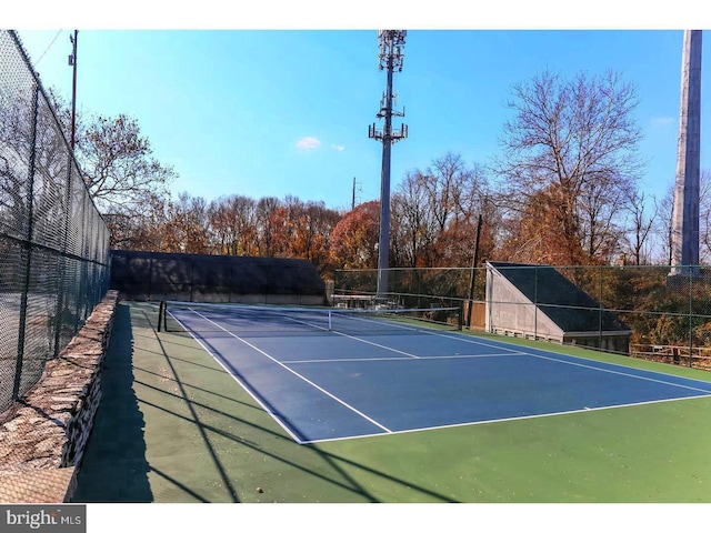 view of tennis court with basketball hoop