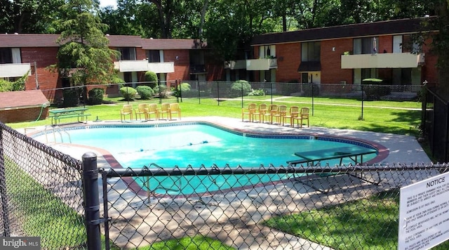 view of swimming pool with a lawn