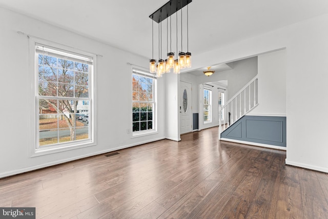 unfurnished dining area featuring plenty of natural light and dark wood-type flooring