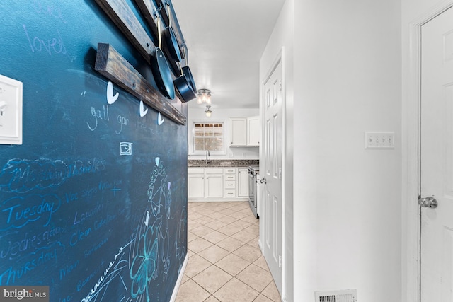 hallway with sink and light tile patterned flooring