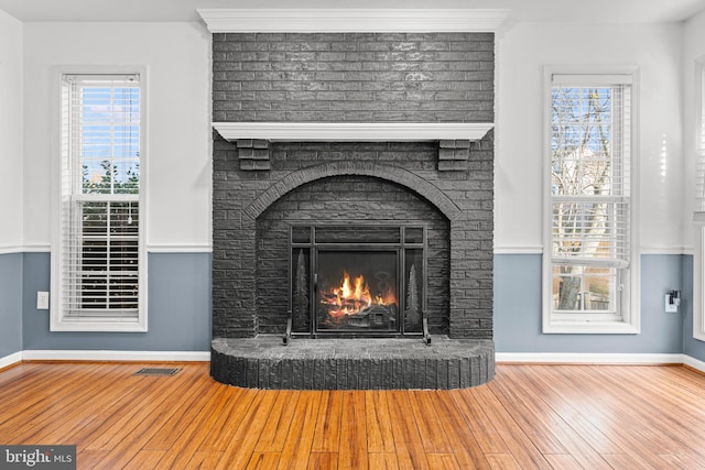 room details with hardwood / wood-style flooring, a fireplace, and crown molding