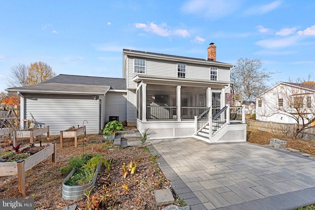 rear view of house with a sunroom and a patio