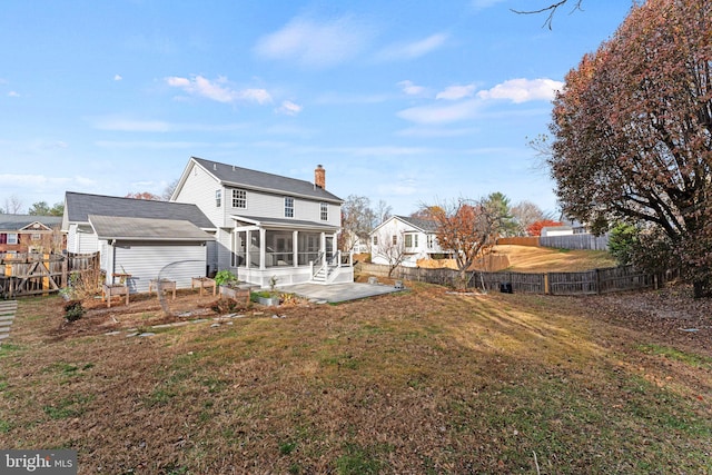 back of property featuring a lawn, a patio area, and a sunroom