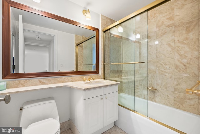 full bathroom featuring vanity, toilet, and shower / bath combination with glass door