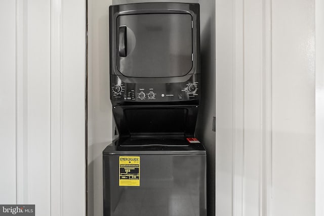 clothes washing area featuring stacked washer and dryer