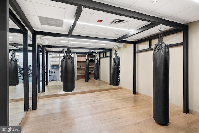 interior space with a paneled ceiling and light wood-type flooring