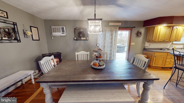 dining room with light hardwood / wood-style floors and a wall mounted AC