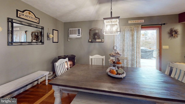 dining room with dark wood-type flooring and a wall unit AC