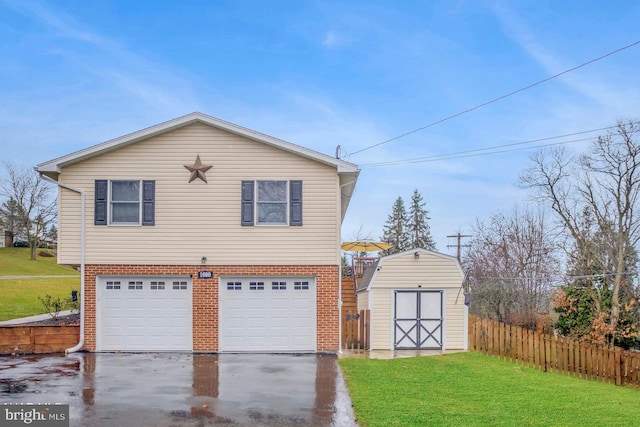 view of front of property featuring a garage, a front yard, and a storage shed