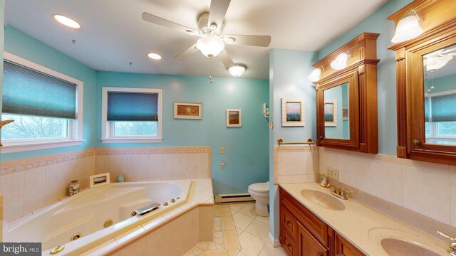 bathroom featuring ceiling fan, baseboard heating, tiled tub, toilet, and vanity