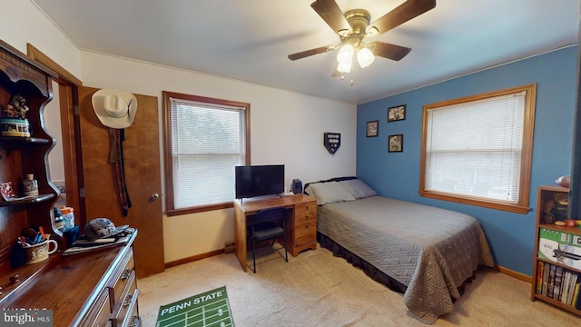 bedroom with ceiling fan and light carpet