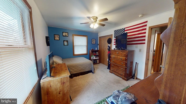 bedroom featuring multiple windows, light colored carpet, and ceiling fan