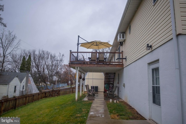 view of yard featuring a deck, an AC wall unit, and a patio area