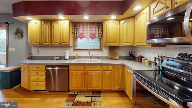 kitchen featuring decorative backsplash, light wood-type flooring, sink, and appliances with stainless steel finishes