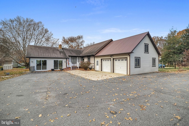 view of front property with central air condition unit and a garage