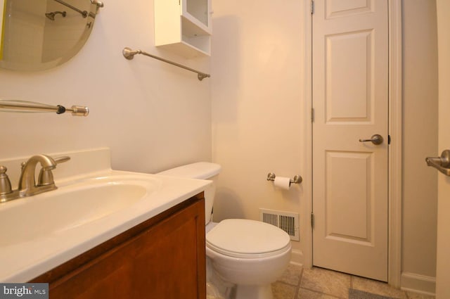 bathroom with tile patterned flooring, vanity, and toilet