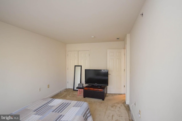 bedroom featuring light carpet and a closet