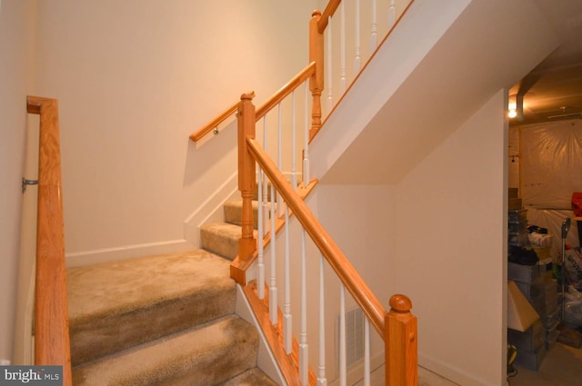 staircase featuring carpet floors and lofted ceiling