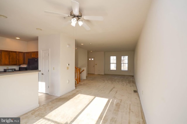 unfurnished living room with ceiling fan and light colored carpet