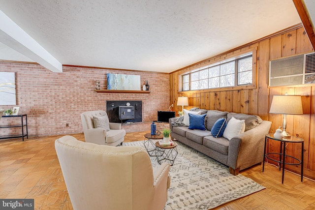 living room with brick wall, a textured ceiling, light parquet floors, a wood stove, and wood walls