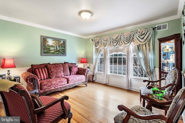living room featuring light hardwood / wood-style floors and crown molding