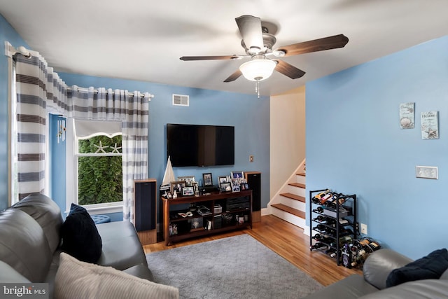 living room with ceiling fan and light hardwood / wood-style flooring